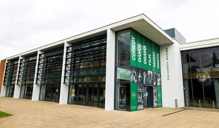 Modern theatre, Grove Theatre, with green banners and ample parking.